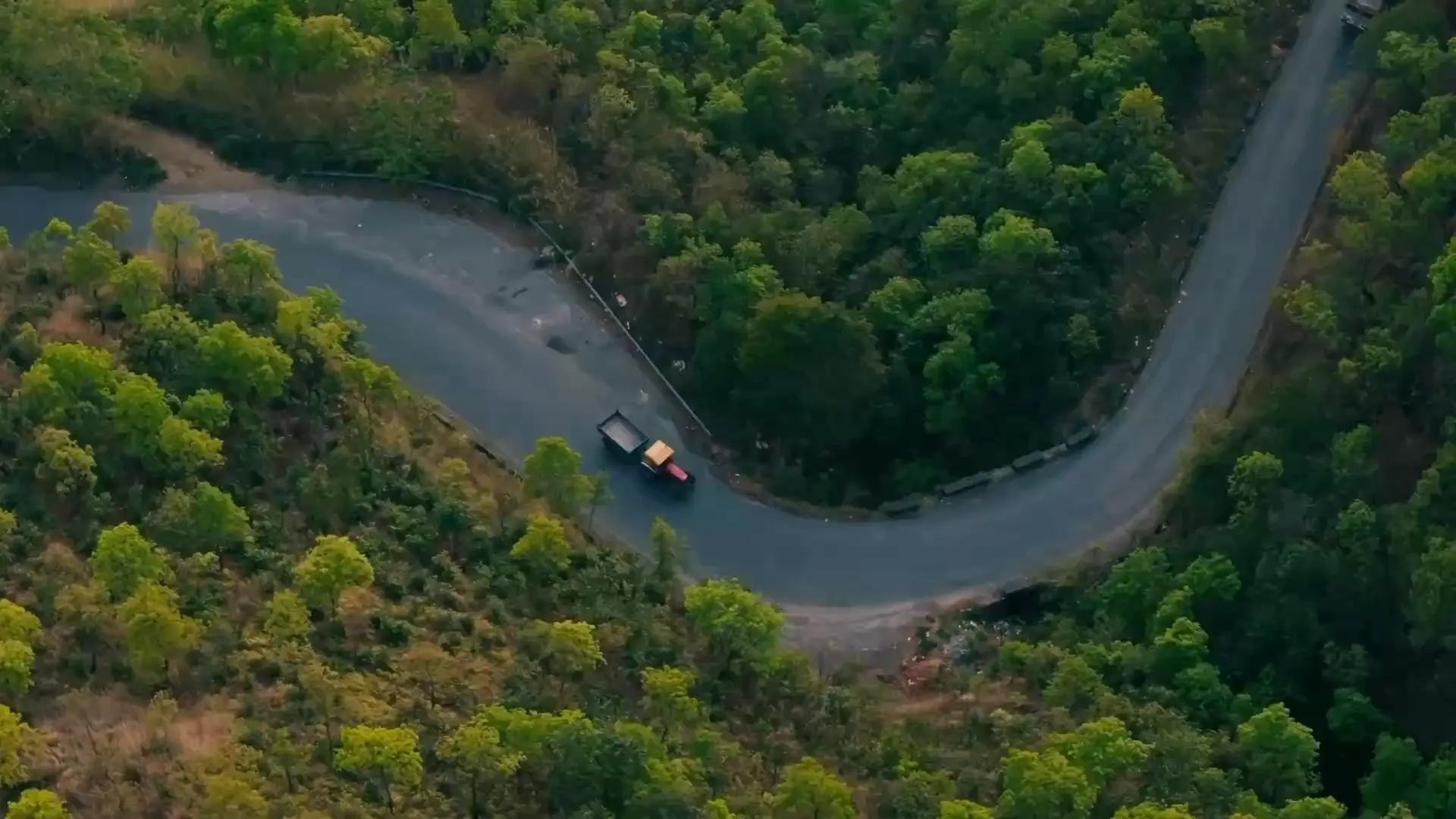Vista aérea de un camión en una carretera de montaña entre árboles